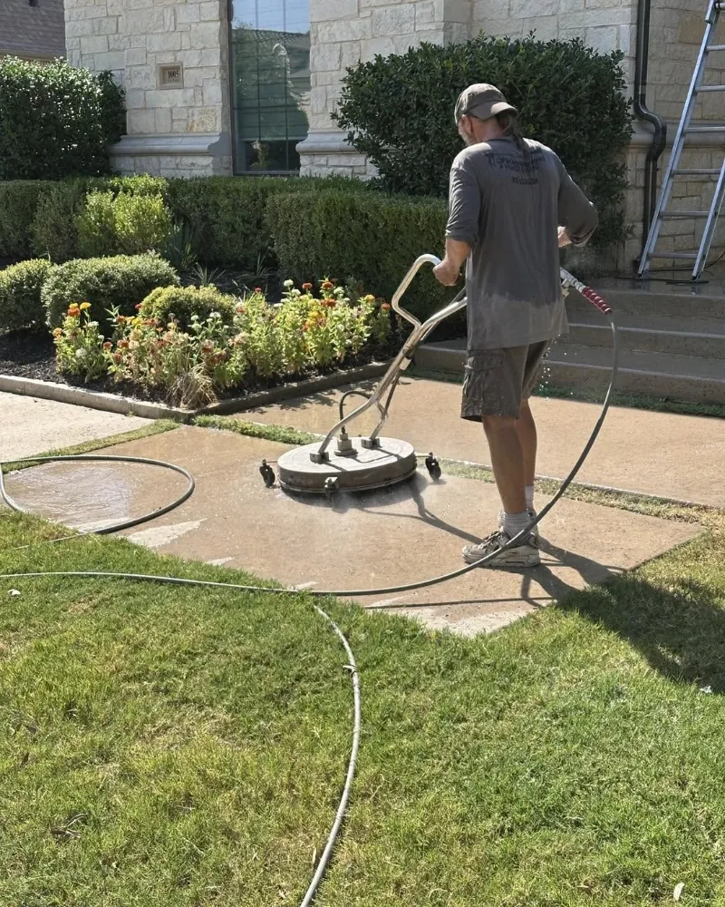 Rotary surface cleaner removing built-up grime from a concrete patio slab in Asheville, NC